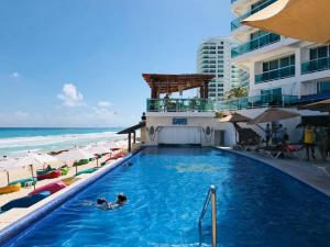 a swimming pool next to a beach and a hotel at A 2 minutos caminando de COCO BONGO! vista al mar - Od110 - in Cancún