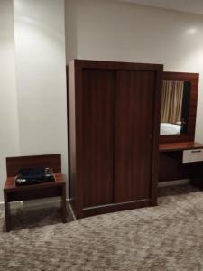 a bedroom with a bed and a wooden cabinet at ريستو للشقق المخدومة in Jeddah