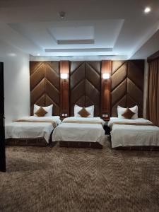 a hotel room with two beds and a headboard at ريستو للشقق المخدومة in Jeddah