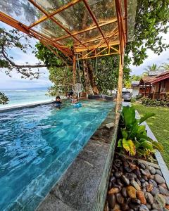 a swimming pool with a view of the ocean at Krui Surfing in Wainapal