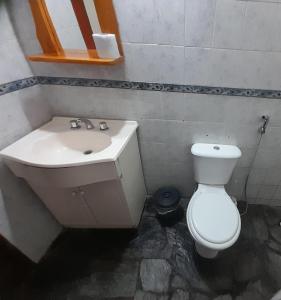 a bathroom with a white toilet and a sink at La Casita del Río in Villa Ciudad Parque