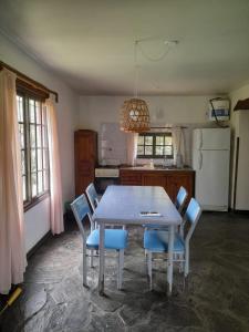 a kitchen with a table with chairs and a refrigerator at La Casita del Río in Villa Ciudad Parque