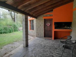a patio with chairs and a door on a house at La Casita del Río in Villa Ciudad Parque