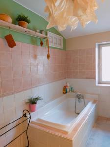 a bath tub in a bathroom with pink tiles at Authentic Mas 265 m2 in Plan-dʼOrgon