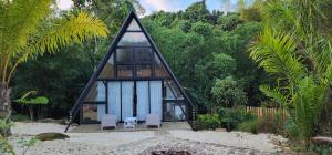 una pequeña casa con techo triangular en la playa en Loma linda Village, en Pedro García