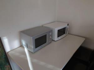 two microwaves sitting on top of a table at Large Apartment, Quality Company Accommodation. in Sundsvall