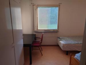 um quarto com uma secretária, uma cama e uma janela em Large Apartment, Quality Company Accommodation. em Sundsvall