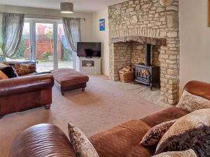 a living room with couches and a stone fireplace at Littlecot in Wyke Regis