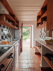 cocina con suelo de baldosa y puerta en Monte Alto da Guerra, en Quinta da Cascalheirinha