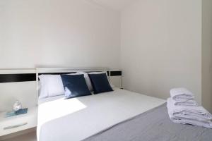 een slaapkamer met een groot wit bed met blauwe kussens bij Just Vero Apartament - GRU in Guarulhos