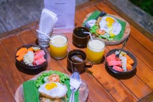dos platos de desayuno y dos vasos de zumo de naranja en I Gusti Nyoman Oka Homestay, en Ubud