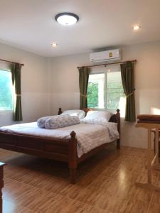 Ban Nai KhlongThanid House的带窗户的房间里有一张床的卧室