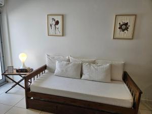 un divano con cuscini bianchi in soggiorno di Pina a Mar del Plata