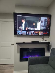 a flat screen tv above a fireplace in a living room at Covenant Properties in Edmonton