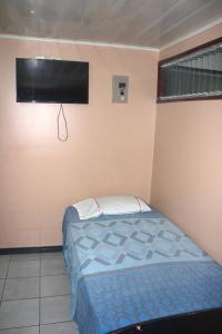1 dormitorio con 1 cama y TV de pantalla plana en Hotel Dorado, en San José