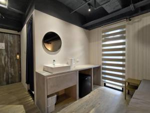 a bathroom with a sink and a mirror at 肆樓寓所 in Tainan