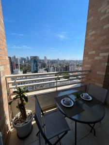 a balcony with a table and chairs and a view of a city at NYC Berrini Duplex Com Vista Deslumbrante!! in Sao Paulo