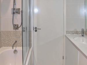 y baño con ducha, bañera y lavamanos. en Maltings Cottage, en Yarmouth