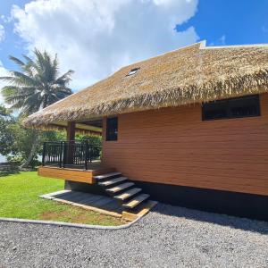 a thatch roofed building with stairs and a grass roof at Bungalow Faré Uta Vairao in Vairao