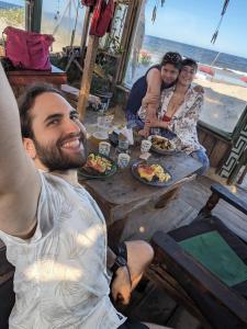 a group of people sitting at a table eating food at Para un poquito relax in Barra de Valizas