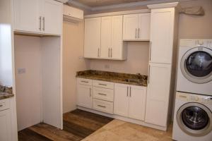 a kitchen with white cabinets and a washer and dryer at La Cresta in Kingstown