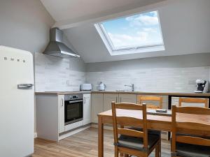 a kitchen with a dining table and a window at The Old Hayloft-uk39431 in Dronfield