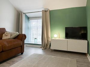 a living room with a couch and a flat screen tv at The Old Hayloft-uk39431 in Dronfield