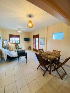 sala de estar con mesa y sillas en Villa Créole vue sur mer des Caraïbes, en Le Carbet