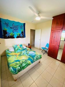 1 dormitorio con 1 cama con una manta colorida en Villa Créole vue sur mer des Caraïbes, en Le Carbet