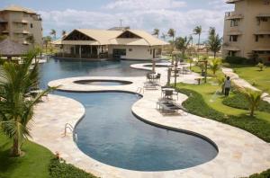 阿基拉斯的住宿－Beach Place Resort - Térreo，棕榈树和建筑度假村的游泳池