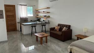 uma sala de estar com um sofá, uma mesa e uma cozinha em Hotel Bella em Tamarindo