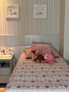 two teddy bears are sitting on a bed at Beach Place Resort - Térreo in Aquiraz