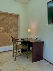 a desk with a chair and a table with a lamp at LUCA HOTEL Heritage Residences Signature Collection in Santo Domingo