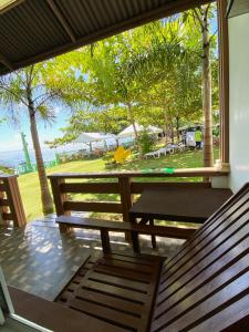 two benches on a porch with a view of the ocean at Oceanfront Beach Resort in Siquijor