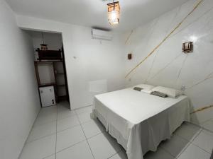 a white bedroom with a bed in a room at Maceió Kite House in Camocim