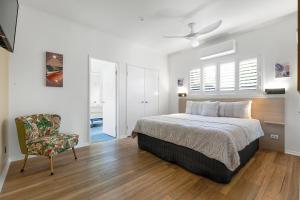 a bedroom with a bed and a chair in it at Jandar Retreat Maleny in Maleny