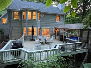 a house with a deck with a table and chairs at LakePath Beach House - XL hot tub, walk to beach in Coloma