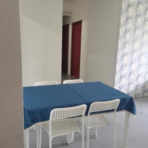mesa con 3 sillas y mantel azul en Homestay Cik Tein Kuala Terengganu, en Kuala Terengganu