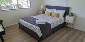 a bedroom with a bed with a blue comforter at Holiday home with fantastic location in Springwood