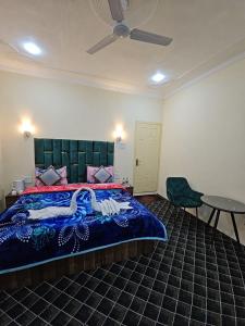 a bedroom with a large bed and a table and a fan at Hotel Nouvella Residency in Srinagar