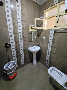 a bathroom with a toilet and a sink in it at Hotel Nouvella Residency in Srinagar