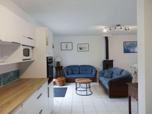 una sala de estar con 2 sofás azules y una mesa. en Maison Sarzeau, 3 pièces, 6 personnes - FR-1-639-102, en Sarzeau