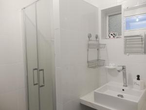 y baño blanco con lavabo y ducha. en Maison Sarzeau, 3 pièces, 6 personnes - FR-1-639-102, en Sarzeau