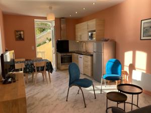 a kitchen with blue chairs and a table in a room at Appartement Sauzon, 2 pièces, 4 personnes - FR-1-418-235 in Sauzon