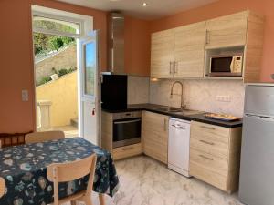 a kitchen with a table and a refrigerator and a sink at Appartement Sauzon, 2 pièces, 4 personnes - FR-1-418-235 in Sauzon