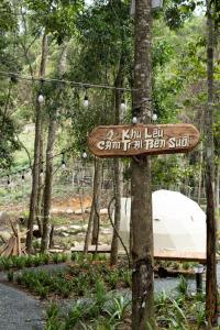 a sign on a tree in a park at LTC Dalat Villa & Resort in Ðưc Trọng