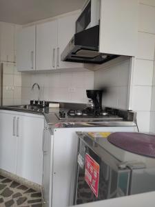 a kitchen with white cabinets and a stove top oven at Bonito apartamento con excelente ubicación in Manizales