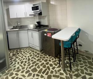 a small kitchen with a counter and a table and chairs at Bonito apartamento con excelente ubicación in Manizales