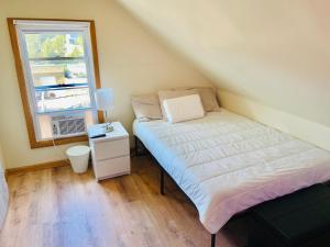 a small bedroom with a bed and a window at Bright, Stylish & Cozy Private Attic Unit near NYC! in Haledon