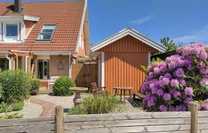 uma casa com uma cerca de madeira e flores roxas em 3 Bedroom Beautiful Home In Hgans em Höganäs
